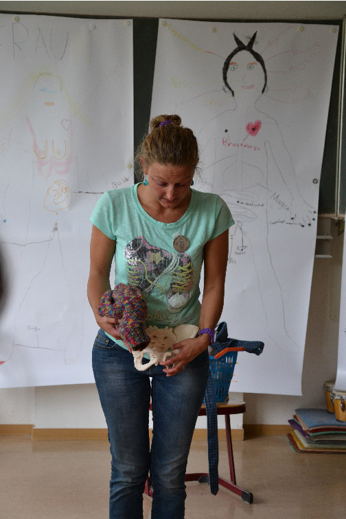 Christalla zeigt Dinge vor zwei Flipcharts